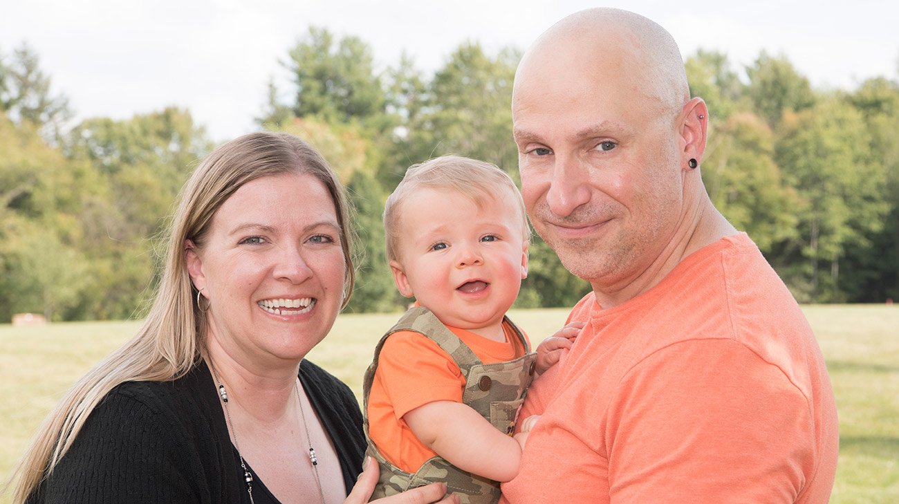 A couple outdoors with their young child